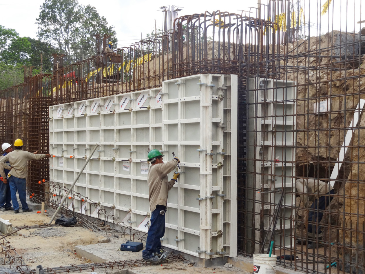 Workers constructing formwork around rebar foundations
