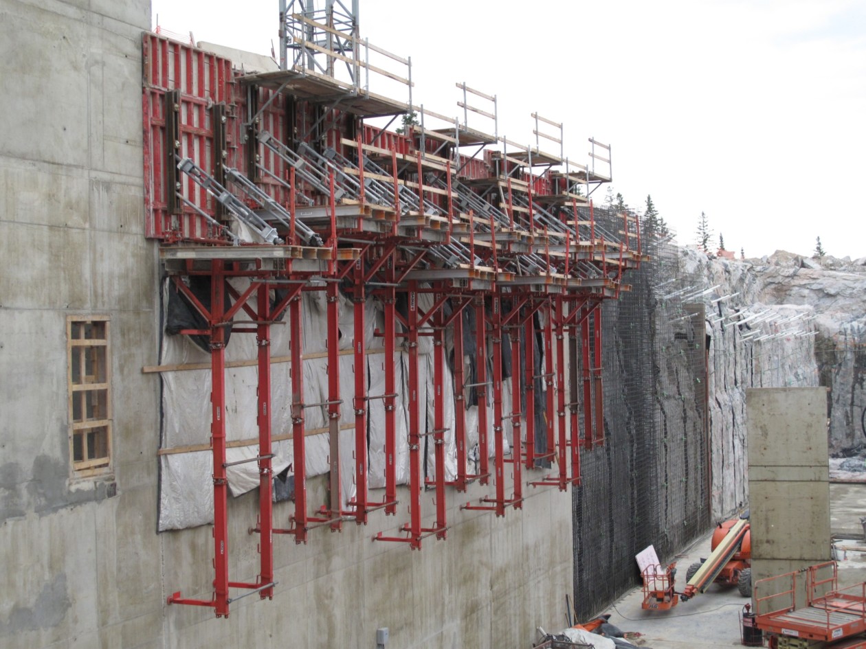 Image of climbing formwork attached to the site of a concrete building during the construction of a scientific plant in USA