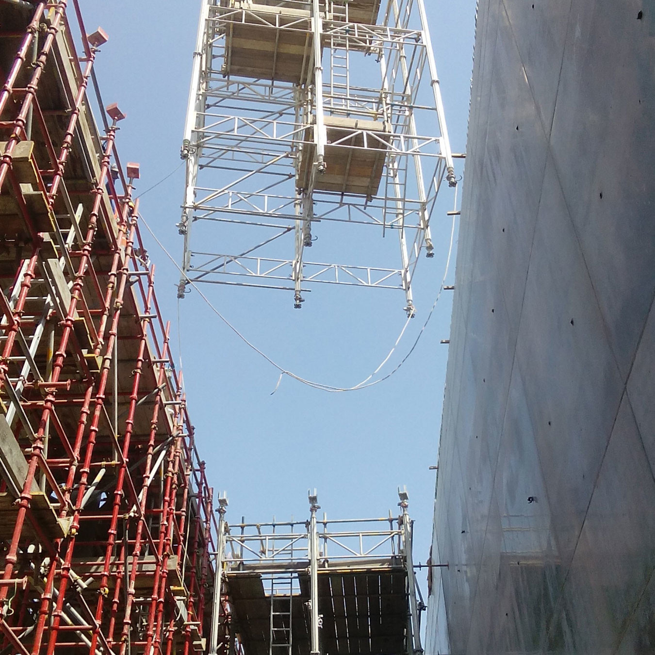 Looking up at shoring tower being craned into position as part of concrete construction
