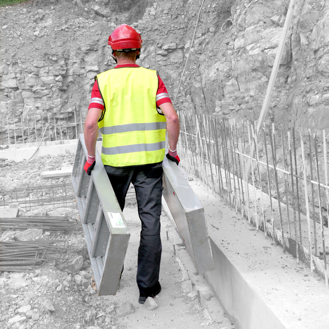 Man carrying two panels as wall formwork is put in place