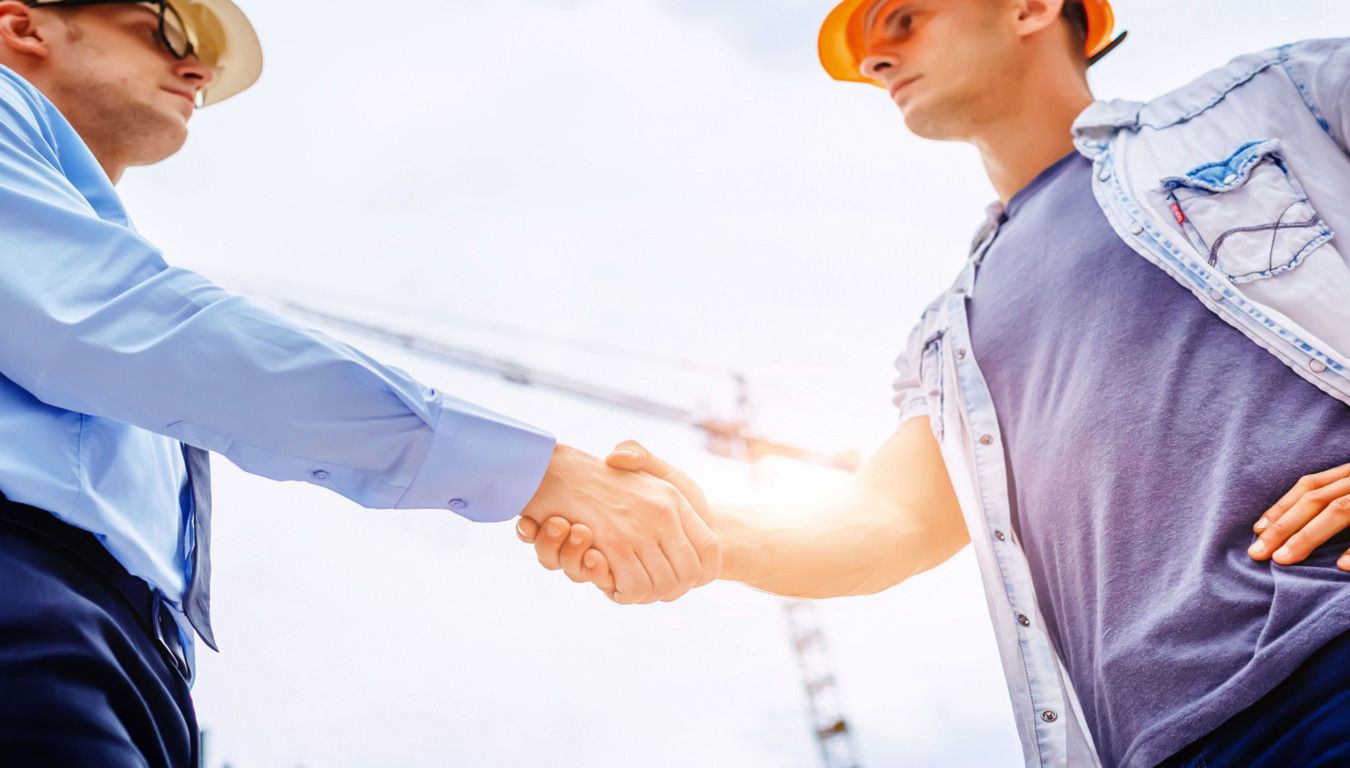 Two workers meeting on a construction site
